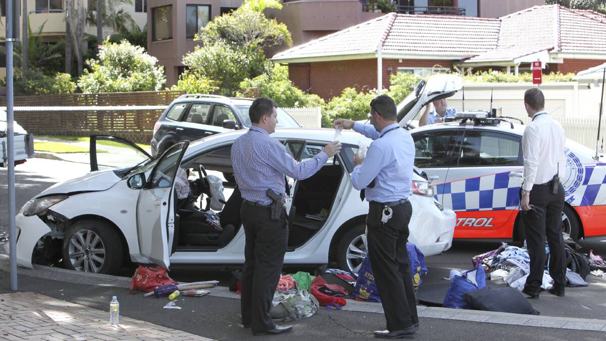Detectives inspect a car after it crashed on Blackett Street, North Wollongong on Friday. Picture: KIRK GILMOUR