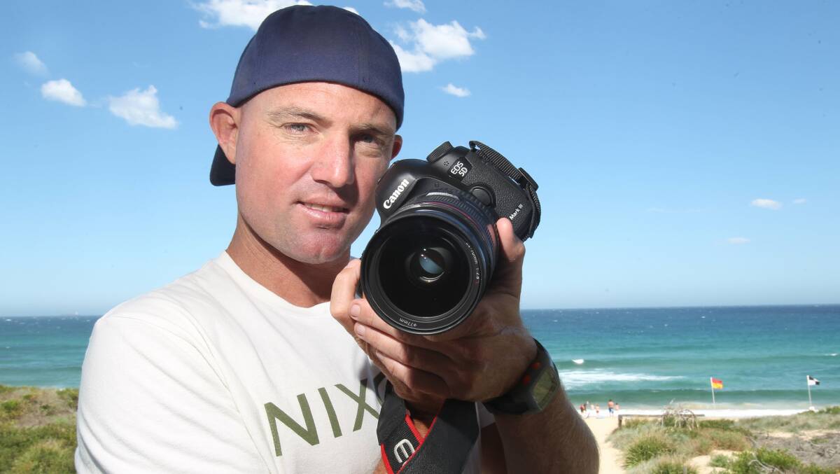 Fairy Meadow lifeguard Ben McRae with his trusty camera. Picture: GREG TOTMAN