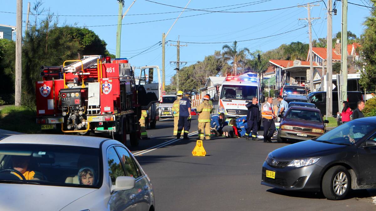 Emergency services treat a pedestrian who was hit by a car on Lawrence Hargrave Drive at Austinmer on Saturday. Photo: KIRK GILMOUR