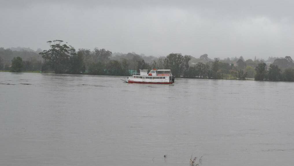 Two large boats used by the Shoalhaven River Cruises for tours on the Shoalhaven River appear to be locked together due to the rising floodwaters on the Shoalhaven River. Photo: ROBERT CRAWFORD 