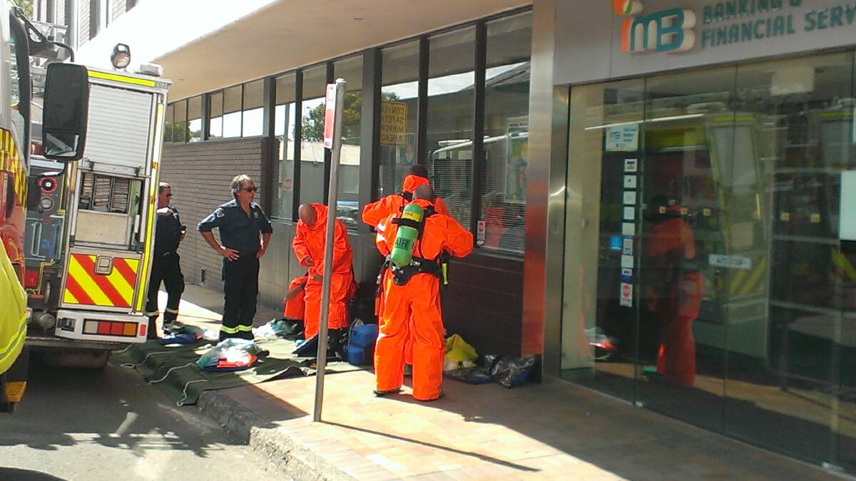 Firefighters don hazmat suits before inspecting a suspicious parcel in an office in Smiths Lane, Nowra.