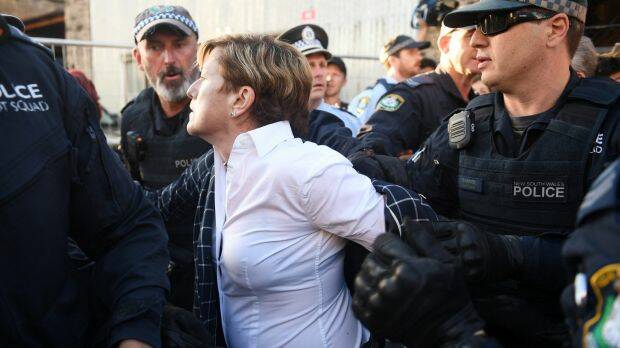 Police escorted Christine Foster past protesters picketing the Liberal fundraising event. Photo: AAP/Brendan Esposito