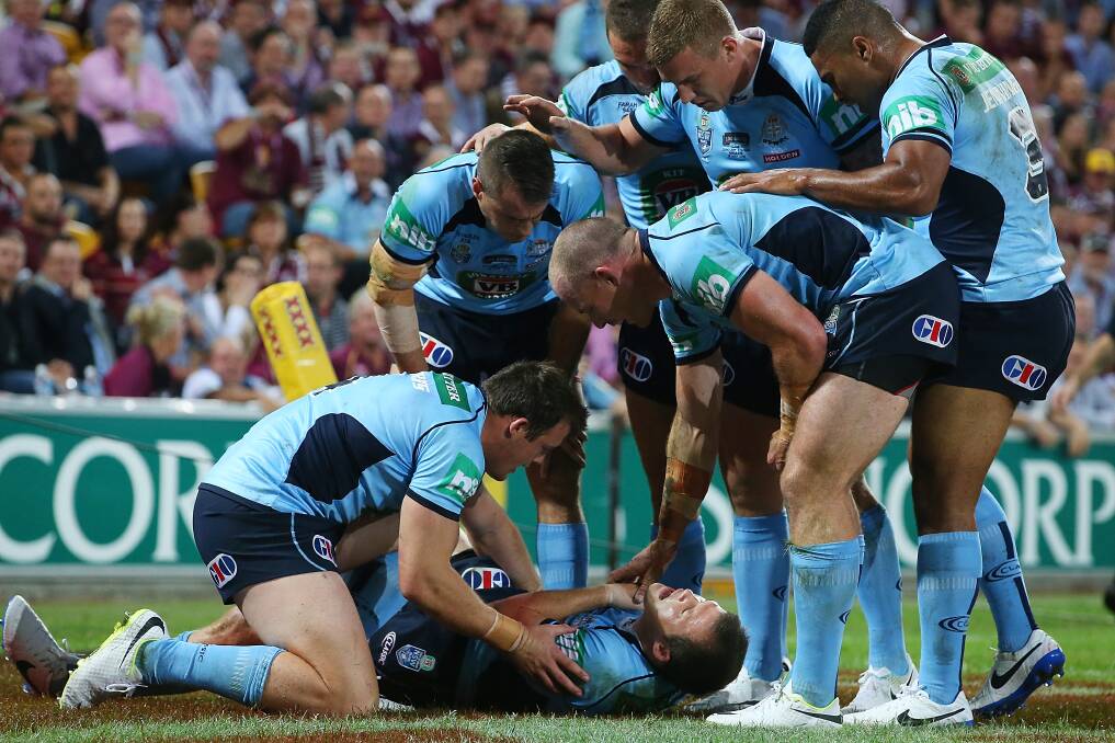 NSW Blues winger Brett Morris surrounded by teammates after injuring his shoulder. Picture: GETTY IMGAES