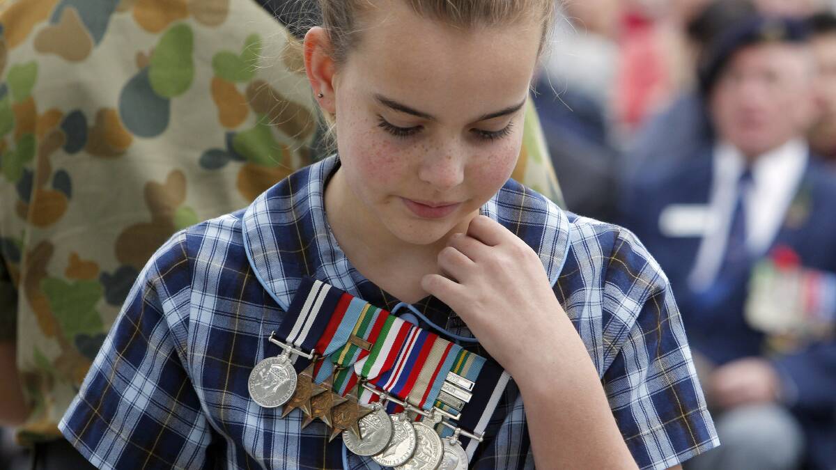 Vice Captain of Shell Cove Public School Christie wears her great-grandfathers medals from WW2 during the wreath laying. Picture: ANDY ZAKELI
