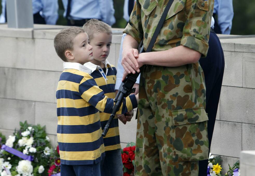 Twins Nathan and Mitchell get up close to a cadet during the wreath laying ceremony. Picture: ANDY ZAKELI
