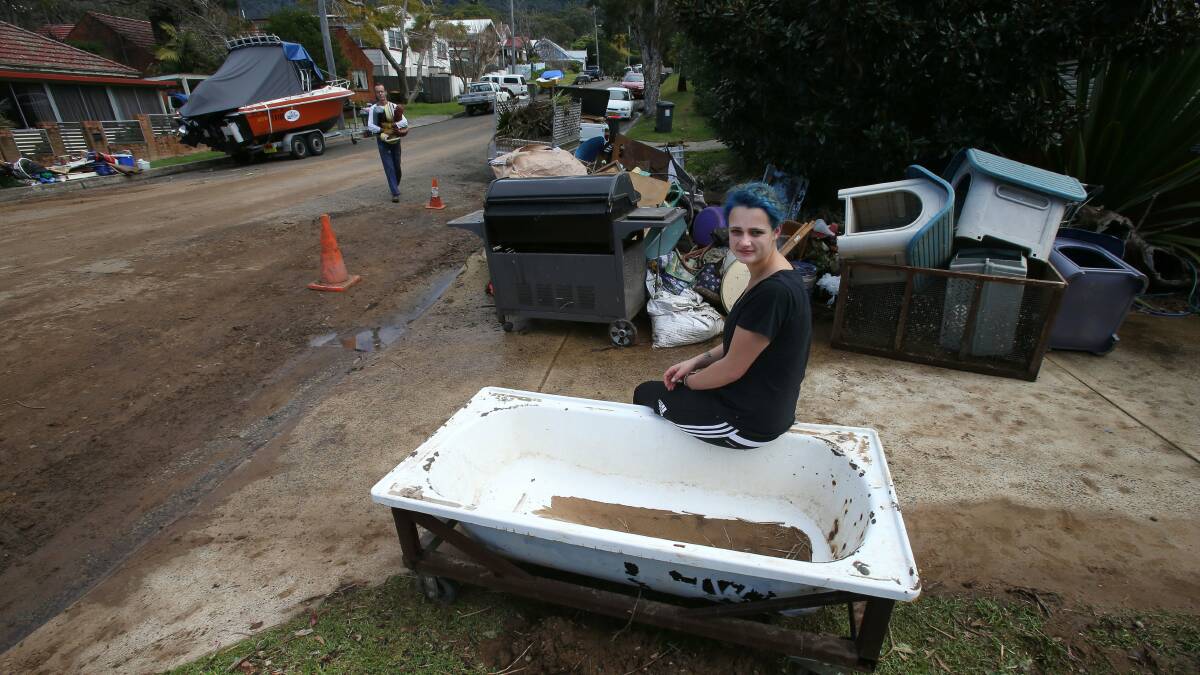 Thirroul resident Billie Rose with a pile of items damaged after Hewitts Creek broke its banks during Monday night’s heavy rain. Pictures: KIRK GILMOUR