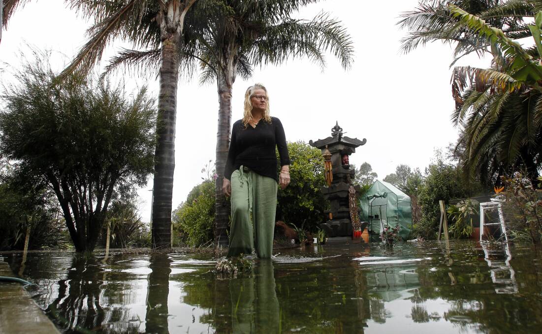 Sharie Clay in her flooded backyard which backs onto the Shoalhaven River. Picture: SYLVIA LIBER