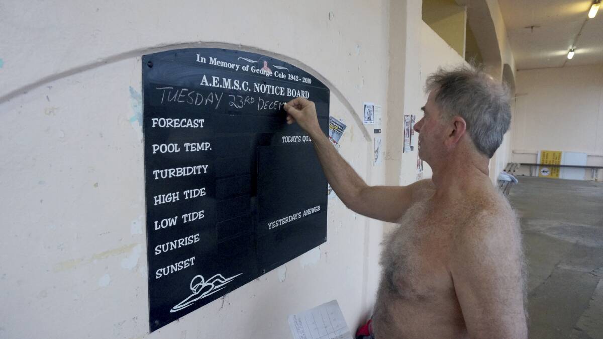 Brian Cummins updates the notice board at Austinmer pools. Picture: KIRK GILMOUR