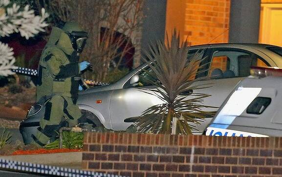 Police in bomb suit inspects car at the scene of the Endeavour Hills shooting. Picture: SCOTT BARBOUR