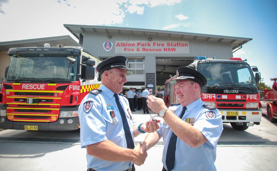 Acting Commissioner Jim Hamilton handing over the keys to the fire station to station commander Dennis Cornell at the Albion Park fire station for the offical opening. Picture: ADAM McLEAN