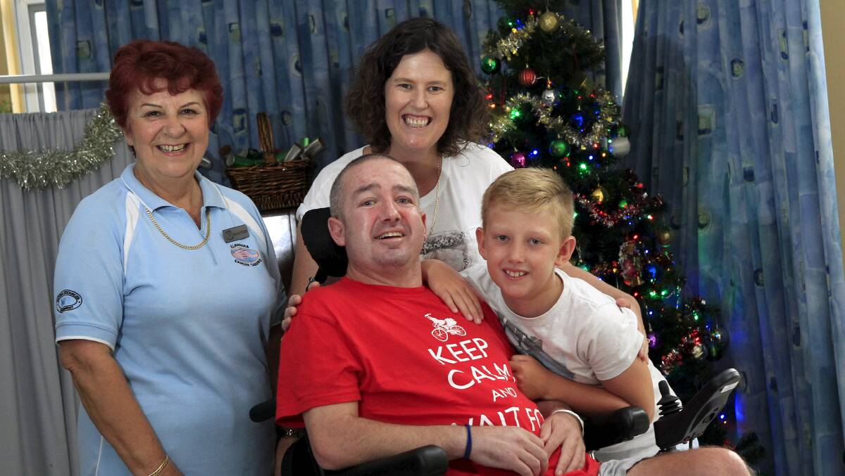 Stroke victim Darren ‘‘Bud’’ Gottaas, with Illawarra Cancer Carers’ Maria Wilson, wife Karen and son Jed, in his motorised wheelchair, is going home for Christmas. Picture: ANDY ZAKELI
