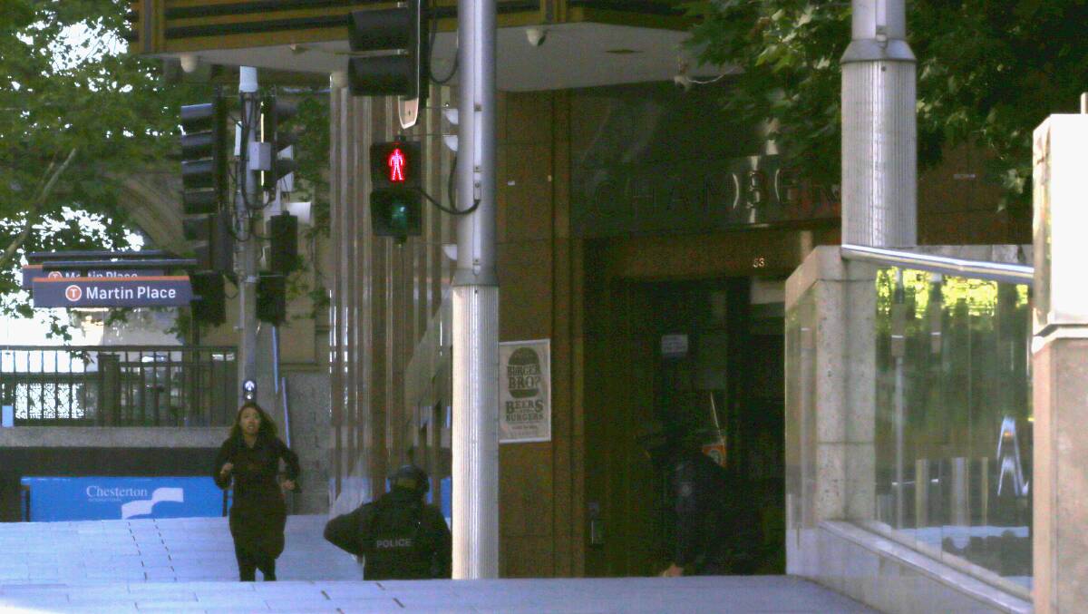 A hostage makes a run to freedom into the protection of police at the siege at Lindt Cafe in Martin Place. Picture: COLE BENNETTS