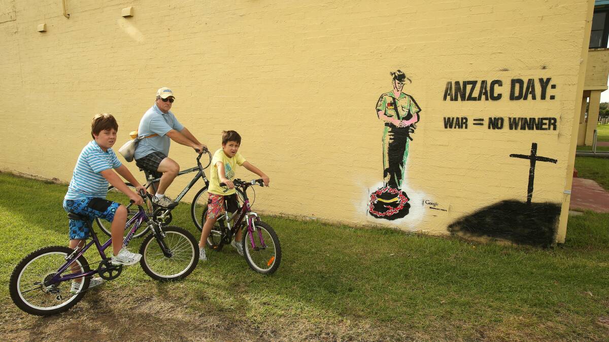 John Schyf of Tarrawanna with visiting grandsons Grady and Flynn Krupa look at the graffiti. Pictture: KIRK GILMOUR