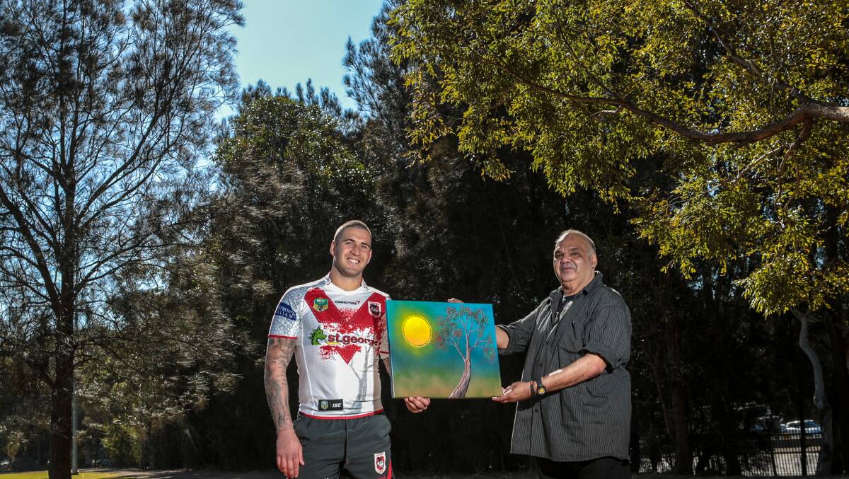 Joel Thompson wears the Dragons indigenous jersey with artist Kevin Butler at the University of Wollongong this week.  Picture: ADAM McLEAN