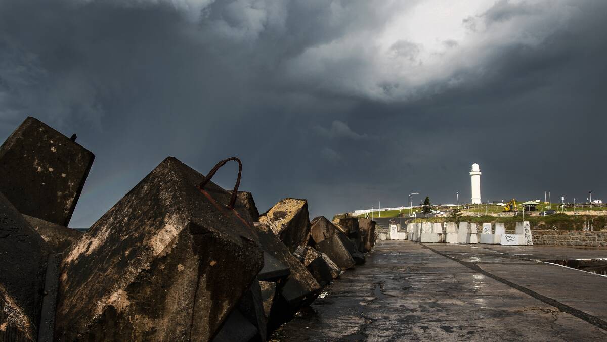 Storm clouds roll in over Wollongong Harbour and lighthouse.  Picture: CHRISTOPHER CHAN