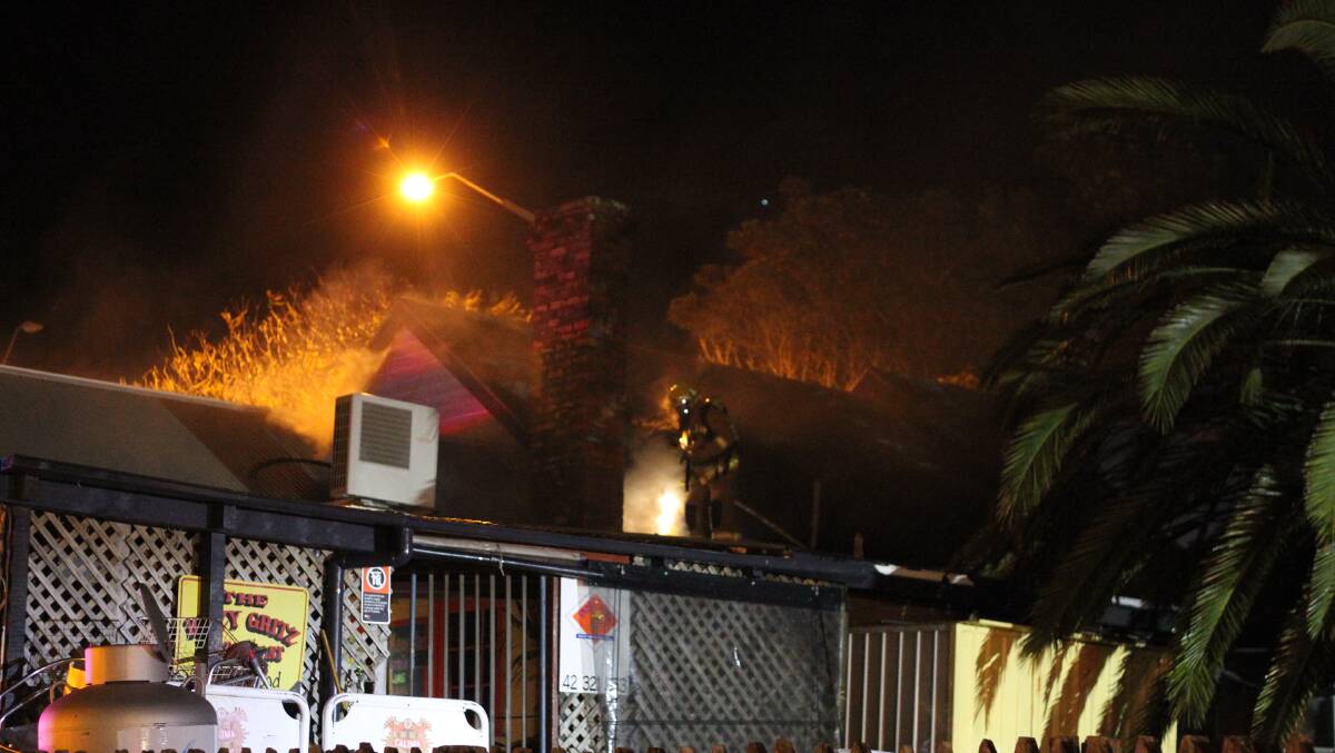 Fire and Rescue NSW work on getting into the roof of the historic Kiama Terrace Houses. Picture:  DAVID HALL