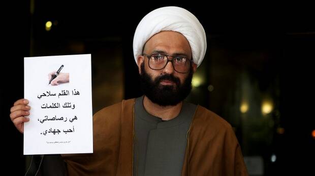 Man Haron Monis holds a sign outside the Downing Centre courts, where he was appearing in relation to sending hate mail to the families of fallen Australian soldiers, in 2010. Picture: KATE GERAGHTY