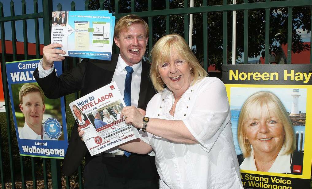 Rivals for the seat of Wollongong, Labor's Noreen Hay and Liberal candidate Cameron Walters getting voters' attention at Berkeley Public School this morning. Picture: GREG TOTMAN