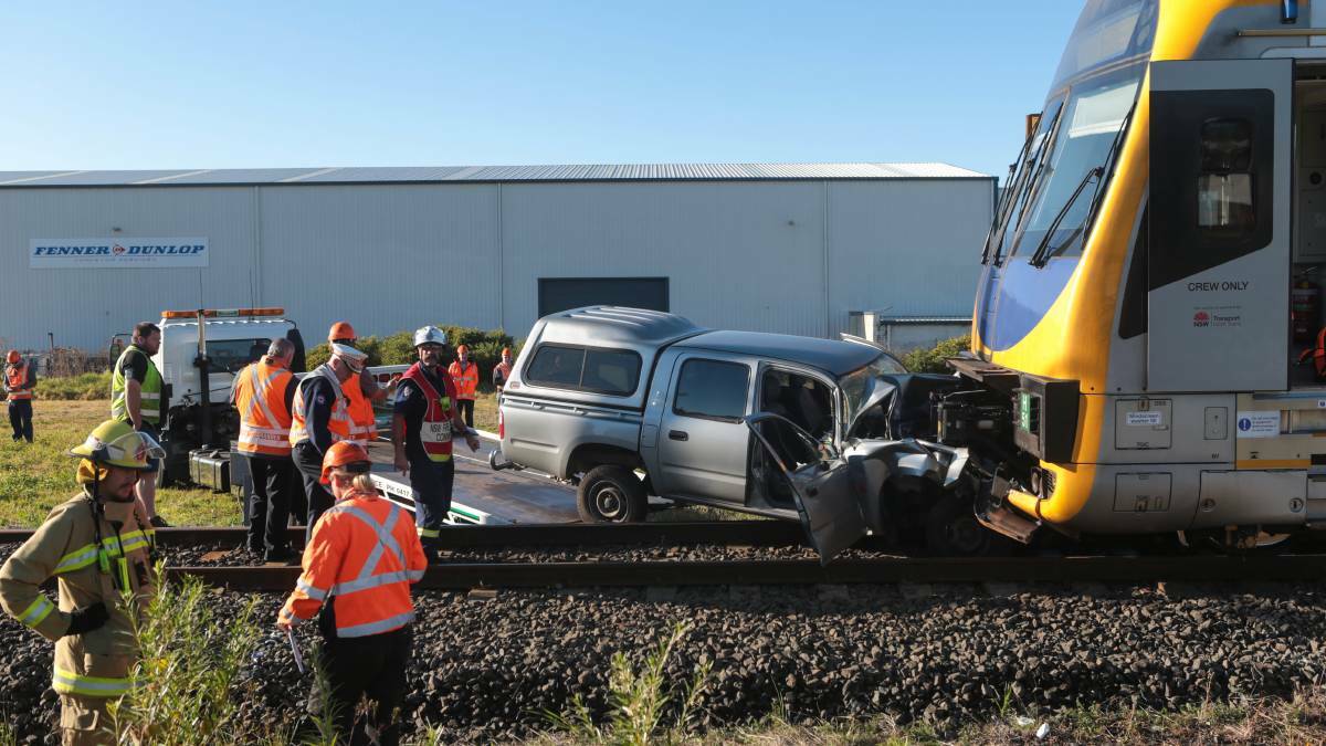 Emergency services at the scene in Unanderra on Monday morning where a car abandoned on railway tracks was hit by a commuter train. Picture: ADAM McLEAN