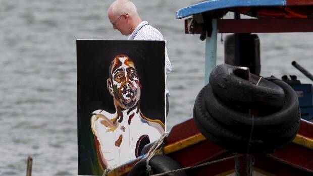 Lawyer Julian McMahon carries Myuran Sukumaran's self portrait of his upper body, with a black hole over his heart. Picture: REUTERS