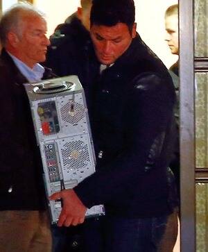 Police carry a computer out of Andreas Lubitz's house.