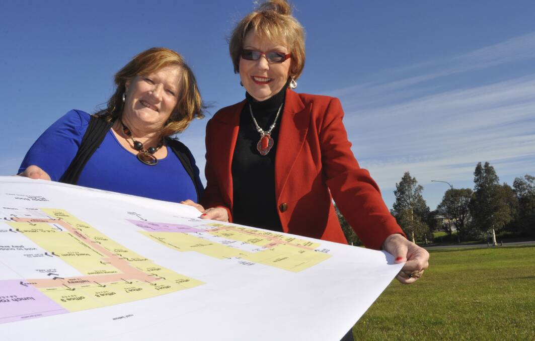 Shellharbour Mayor Marianne Saliba and Kidzwish founder Chris Bevan look over the plans for the new centre at the proposed site at Flinders. Picture: ELIZA WINKLER