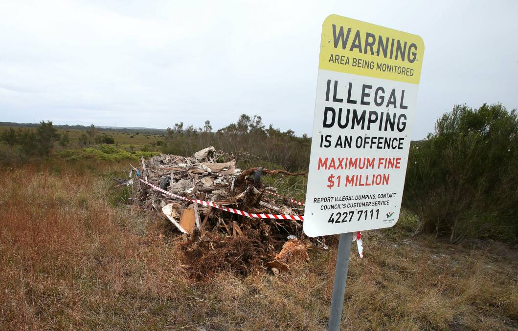 Illegal dumpers have left a huge pile of rubbish that stretches almost 10 metres - right next to a Wollongong City Council ‘‘no dumping’’ sign. Picture" KIRK GILMOUR
