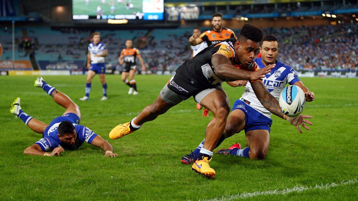 Kevin Naiqama sets up the Wests Tigers' first try for James Tedesco (behind him) by keeping the ball alive as it seems bound for the deadball line. Picture: GETTY IMAGES