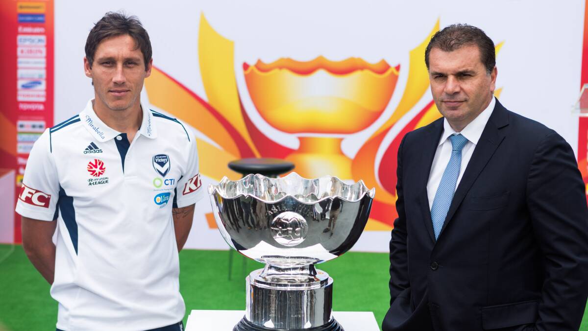 Ange Postecoglou and Mark Milligan stand with the Asian Cup in Melbourne's Federation Square. Photo: GREG BRIGGS
