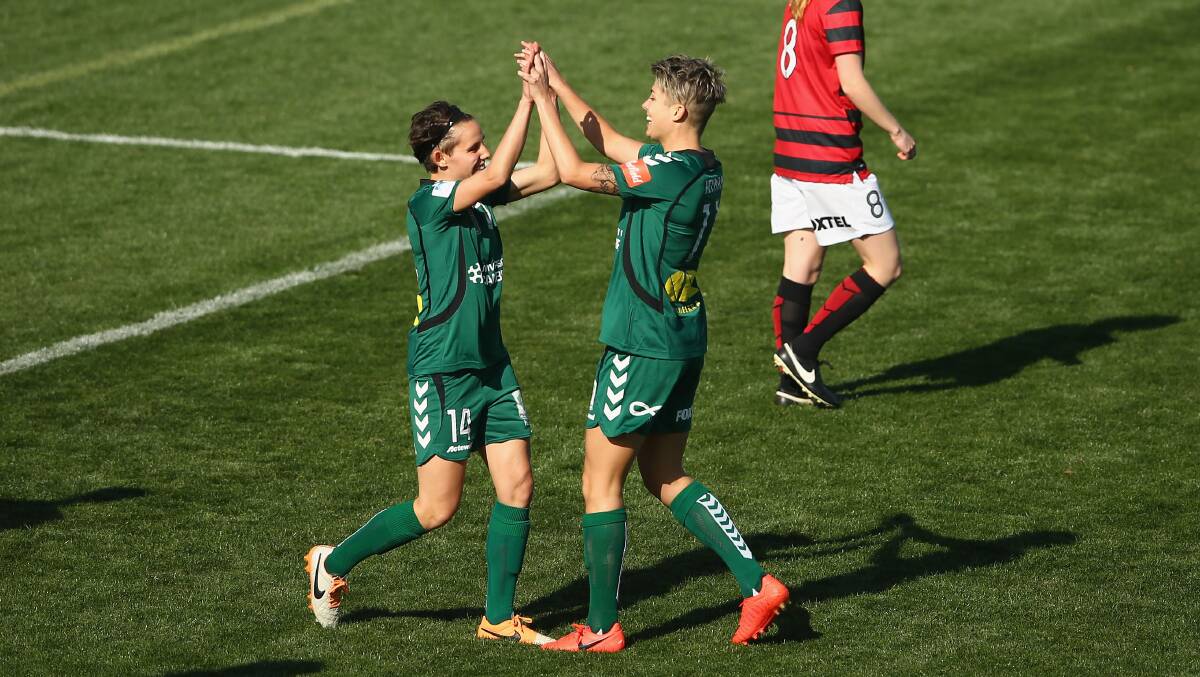 Michelle Heyman and Ashleigh Sykes of Canberra United celebrate after Heyman scored on Sunday. Picture: GETTY IMAGES
