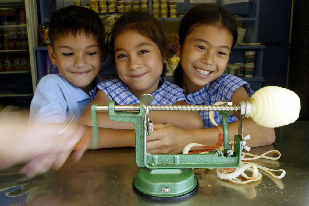 Lawrence Gallera, 8, and sisters Alison 6 and sister Stephanie Dinh 8, of Berkeley West Public school with the popular slinky apple machine.
