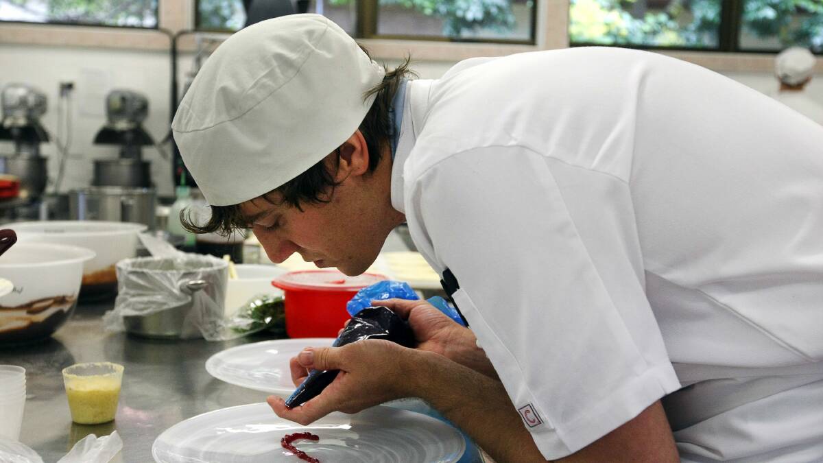 Kallan Braigg puts the finishing touches to his dish in the NSW Bake Skills competition. Picture: SYLVIA LIBER