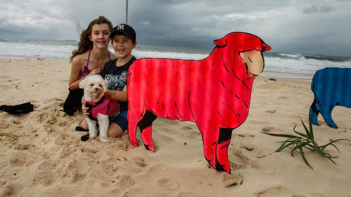 Siblings Natalie and Cooper and their dog Sam check our beach art  at Thirroul Seaside and Arts Festival. Picture: CHRISTOPHER CHAN