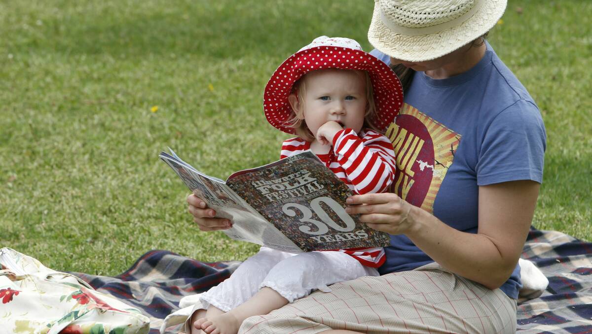 Layla Pratt, 16 months, and her mum, Julie, check out the 2015 music program during the launch of the Illawarra Folk Festival in Civic Plaza. Picture: ANDY ZAKELI