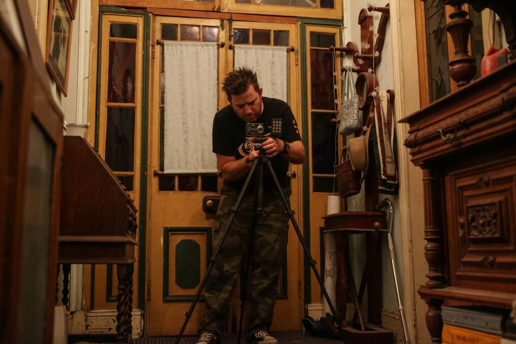Dan McMath sets up recording equipment in his hunt for spirits. Picture: CHRISTOPHER CHAN