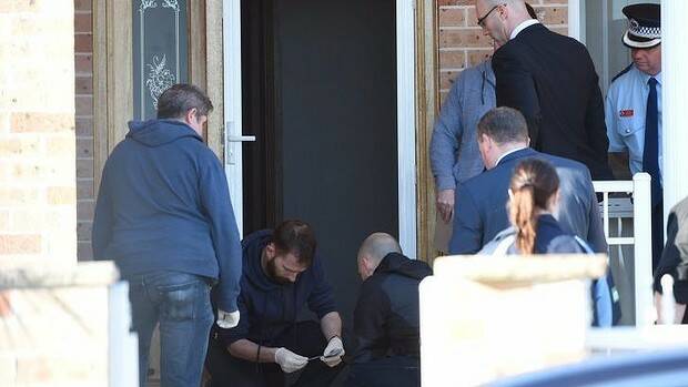 Police at the scene of one of the raids in Guildford. Picture: NICK MOIR