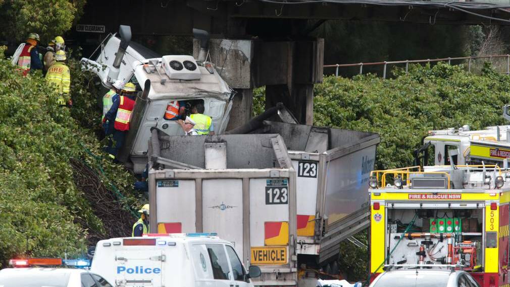 Emergency crews work to free a truck driver from his cabin on Five Islands Road in December. Picture: ADAM McLEAN