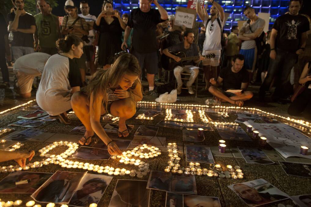 Left-wing Israelis light candles for the Palestinian and Israeli victims in a protest against Israel's military operation in the Gaza Strip in Tel Aviv. Picture: GETTY IMAGES 