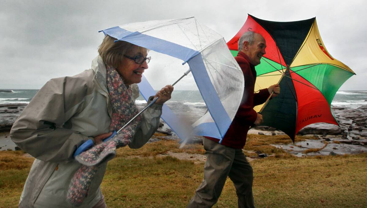 Mary and Patrick Foy of Shell Cove brave the rain at Shellharbour. Pictures: SYLVIA LIBER