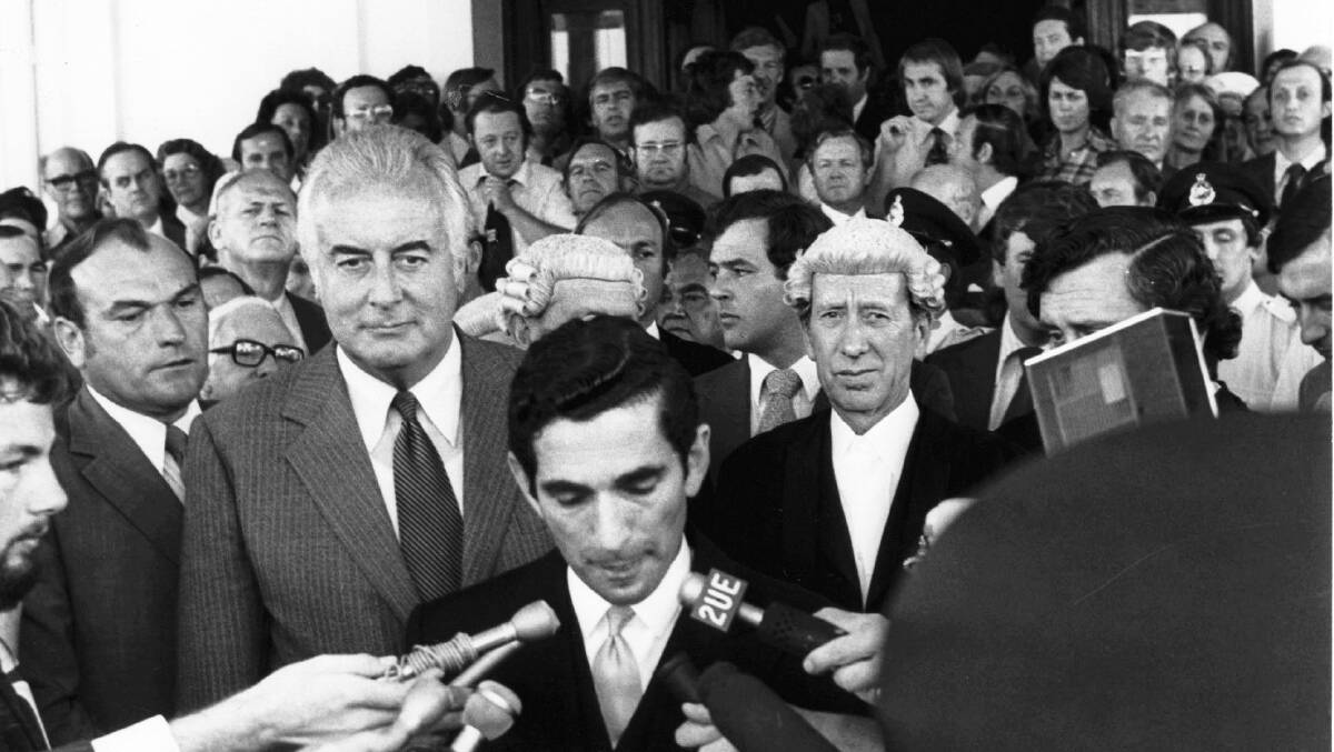 Gough Whitlam stands behind David Smith, the secretary to the Governor-General, as he reads the proclamation dissolving parliament following the dismissal of the Whitlam government. Picture: PETER WELLS