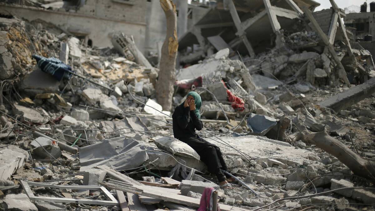 A Palestinian woman reacts as she sits on the rubble of her destroyed house after returning to Beit Hanoun town, in the northern Gaza Strip. Picture: REUTERS