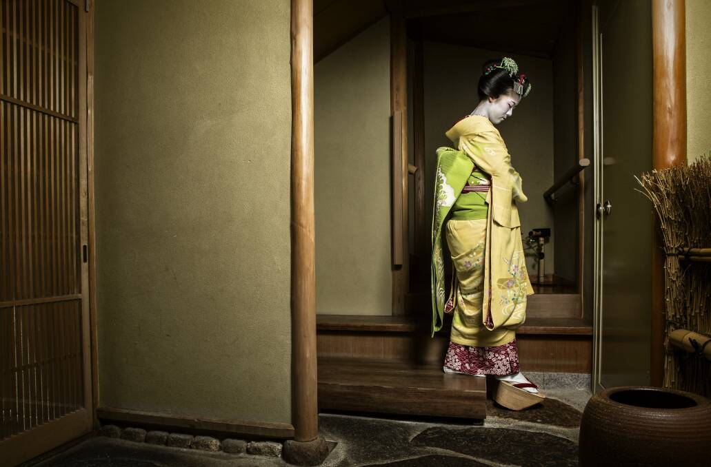 TOSHISUMI. Kyoto, Japan. Toshisumi is a maiko (apprentice geisha). Because she is not yet a fully fledged geisha or geiko as they are known in Kyoto, she needs to perform her duties a little differently than fully fledged professionals. Toshisumi had just finished an afternoon appointment, but because she is only an apprentice she is required to leave her guests in the communal bar once she has finished her allotted appointment. Here Toshisumi replaces her getas as she leaves a teahouse after escorting her guests to the communal bar. Pictures courtesy of benmcraephotography.com