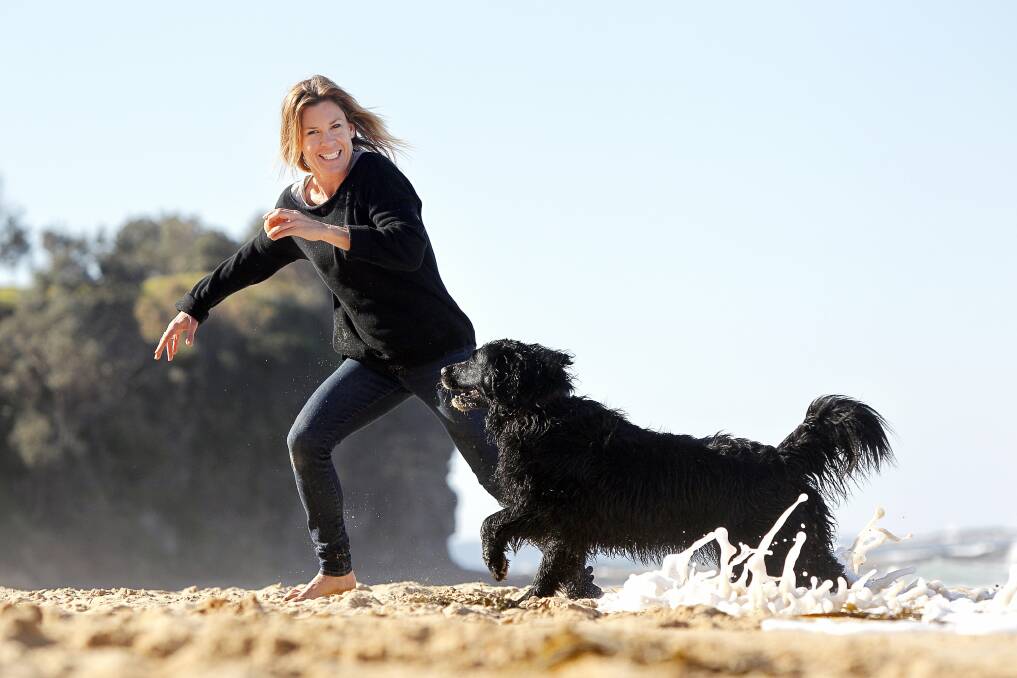 Sarah Goss with her dog Pudding, playing on the off-leash area at Sharkeys Beach. Picture: SYLVIA LIBER