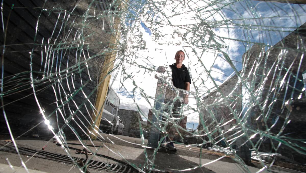 Simple Cycles store manager Kate McGuinn inspects a smashed window where thieves attempted to break in on Wednesday night. Picture: ADAM McLEAN