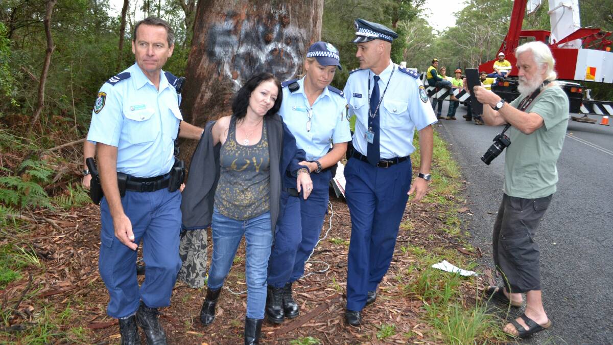 Protester Alison Darling is led away by police before contractors begin removing the bum tree. Picture: ROBERT CRAWFORD