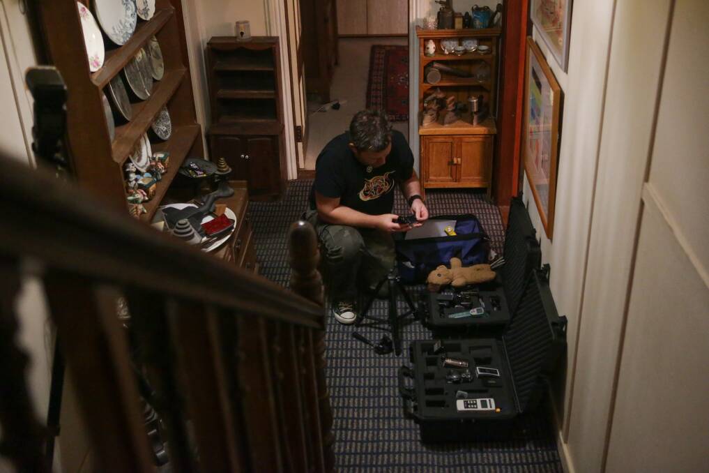 Dan McMath sets up recording equipment in his hunt for spirits. Picture: CHRISTOPHER CHAN