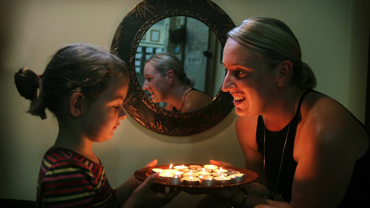 Liberty, 4, and mum Belinda Baines burn tea lights for Earth Hour. Pictures: SYLVIA LIBER