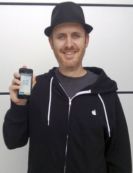 UOW computer science graduate Craig Stanford holds a phone with the app he developed, Clipp.