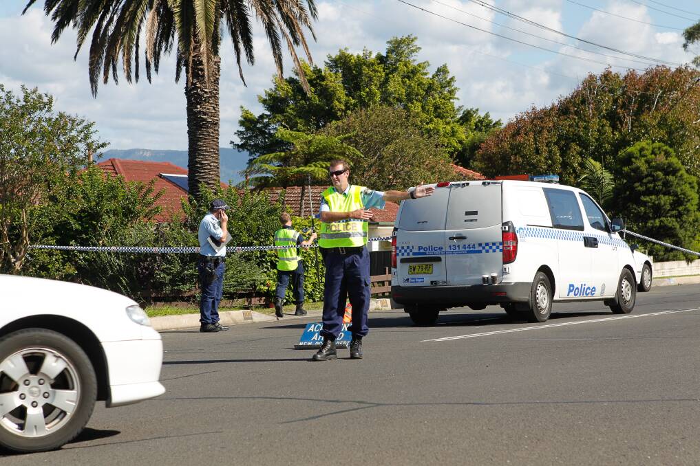 Police and police forensics investigate a suspected hit-and-run on Northcliffe Drive, Lake Heights. Picture: CHRISTOPHER CHAN
