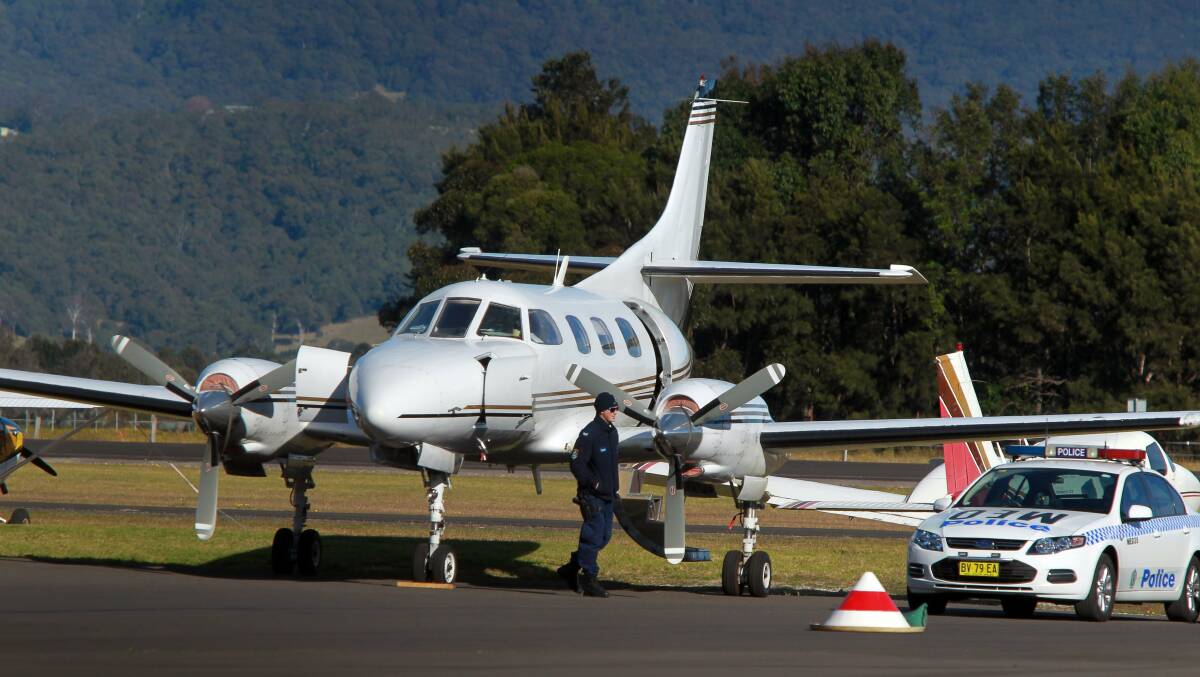 Police guard the plane at Albion Park airport on Thursday. Picture: SYLVIA LIBER